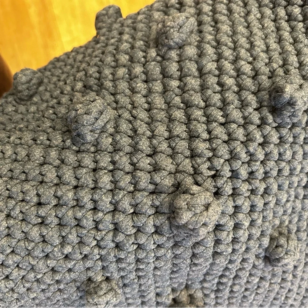 Hand-crocheted blue tote bag with bobble stitch details.